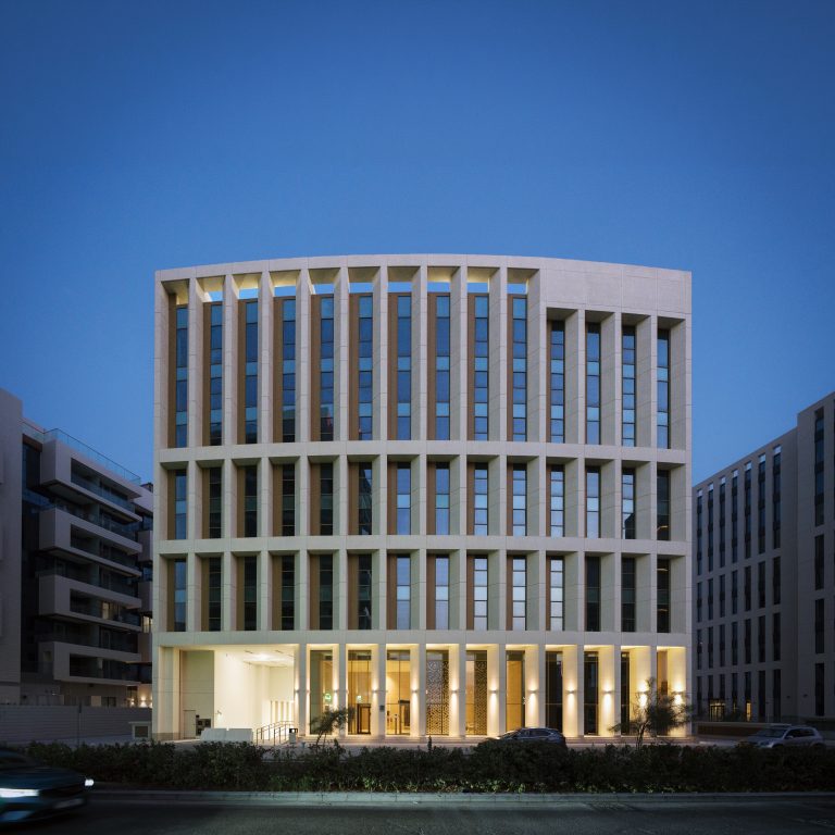 Exterior view of the C-28 building at Al Raha Beach, Abu Dhabi, at dawn.